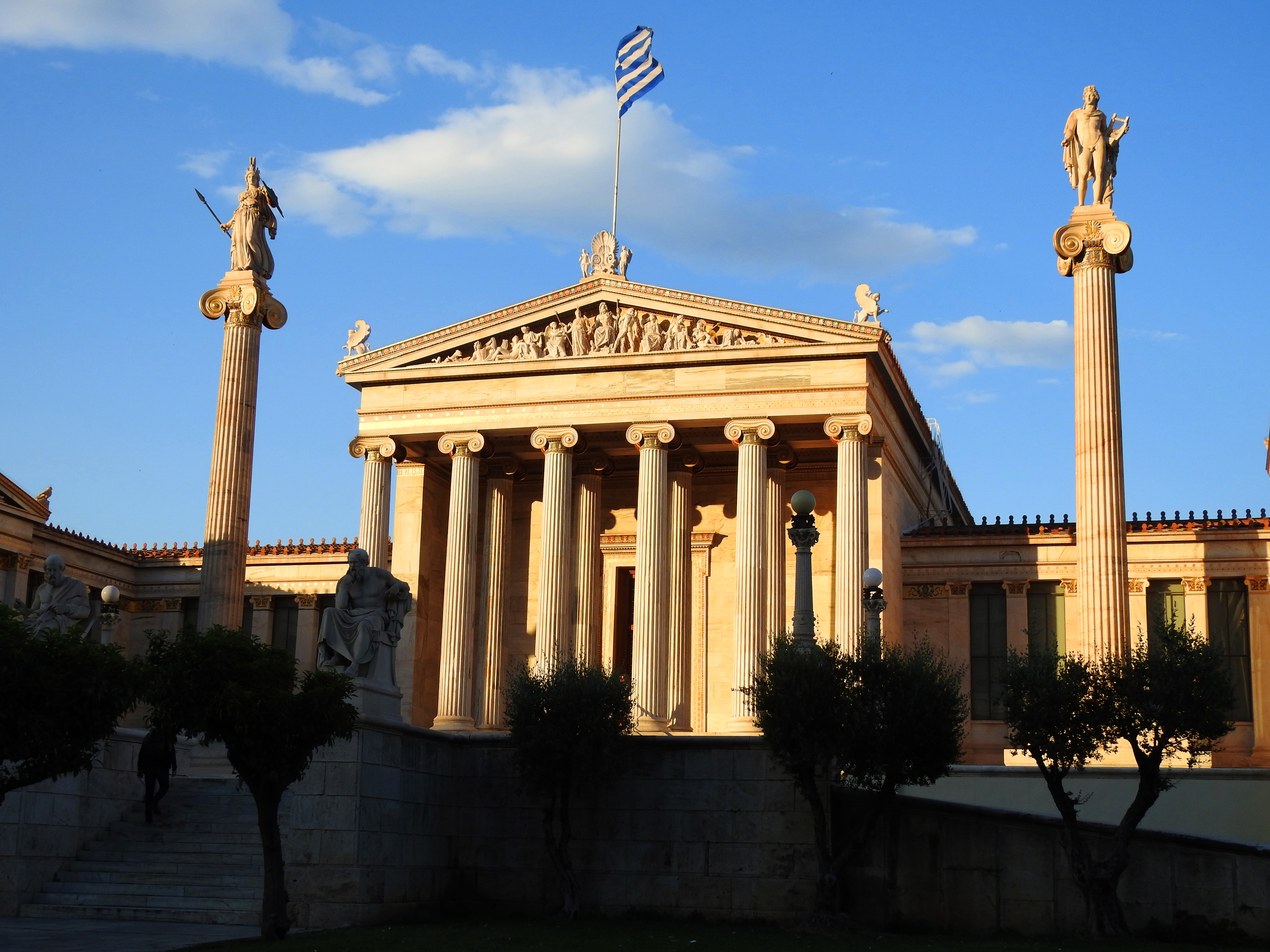 The Academy of Athens, its Ionic columns and statues of Athena and Apollo lit at sunset