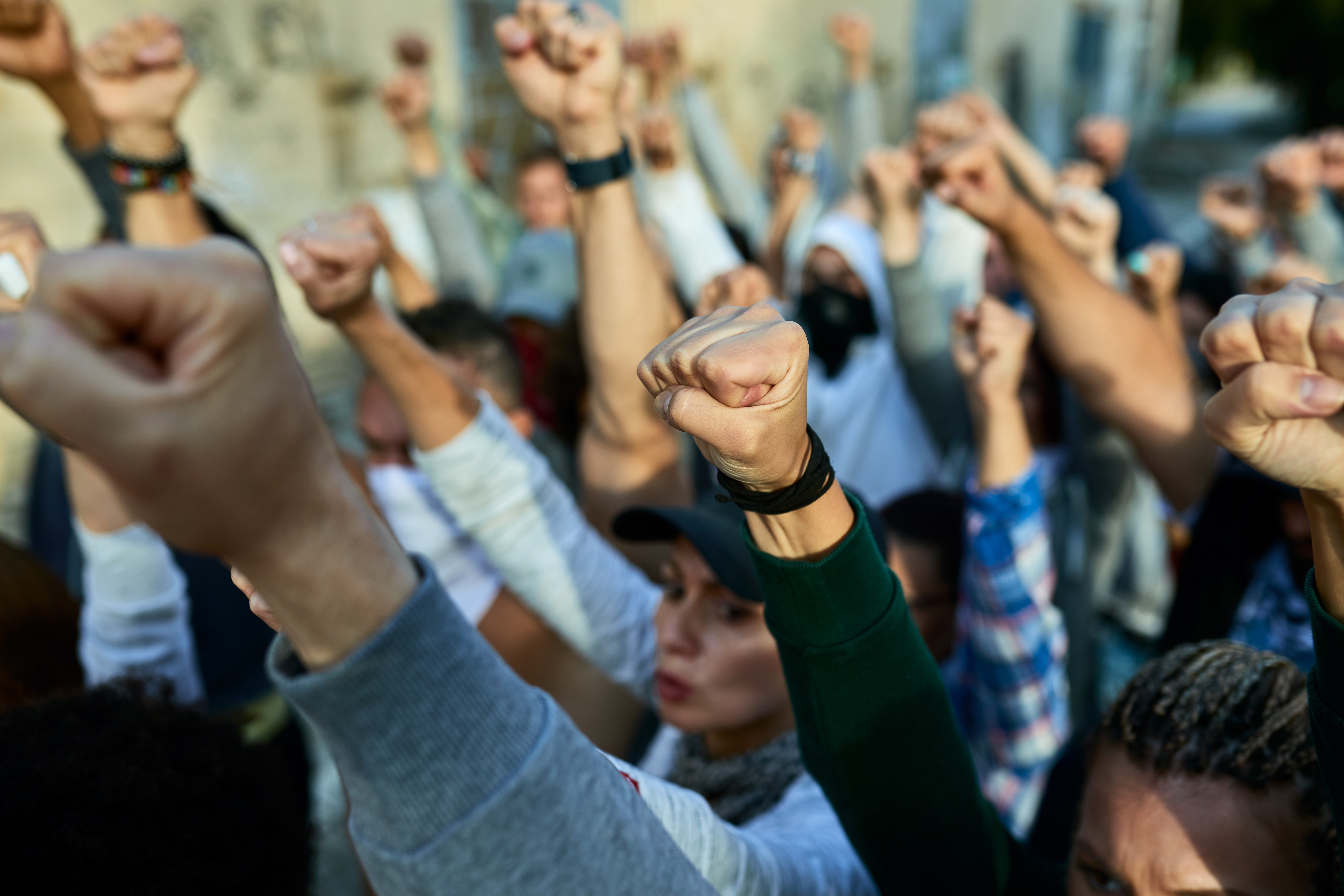 A crowd with fists raised at a public demonstration